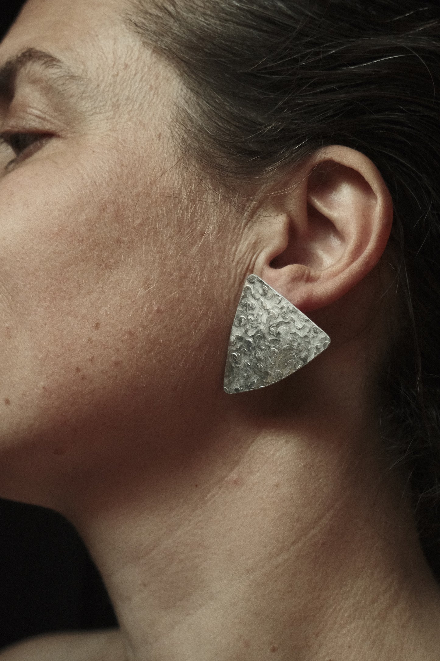 Boucles d’oreilles de forme triangulaires texturés. Couleur argenté.
